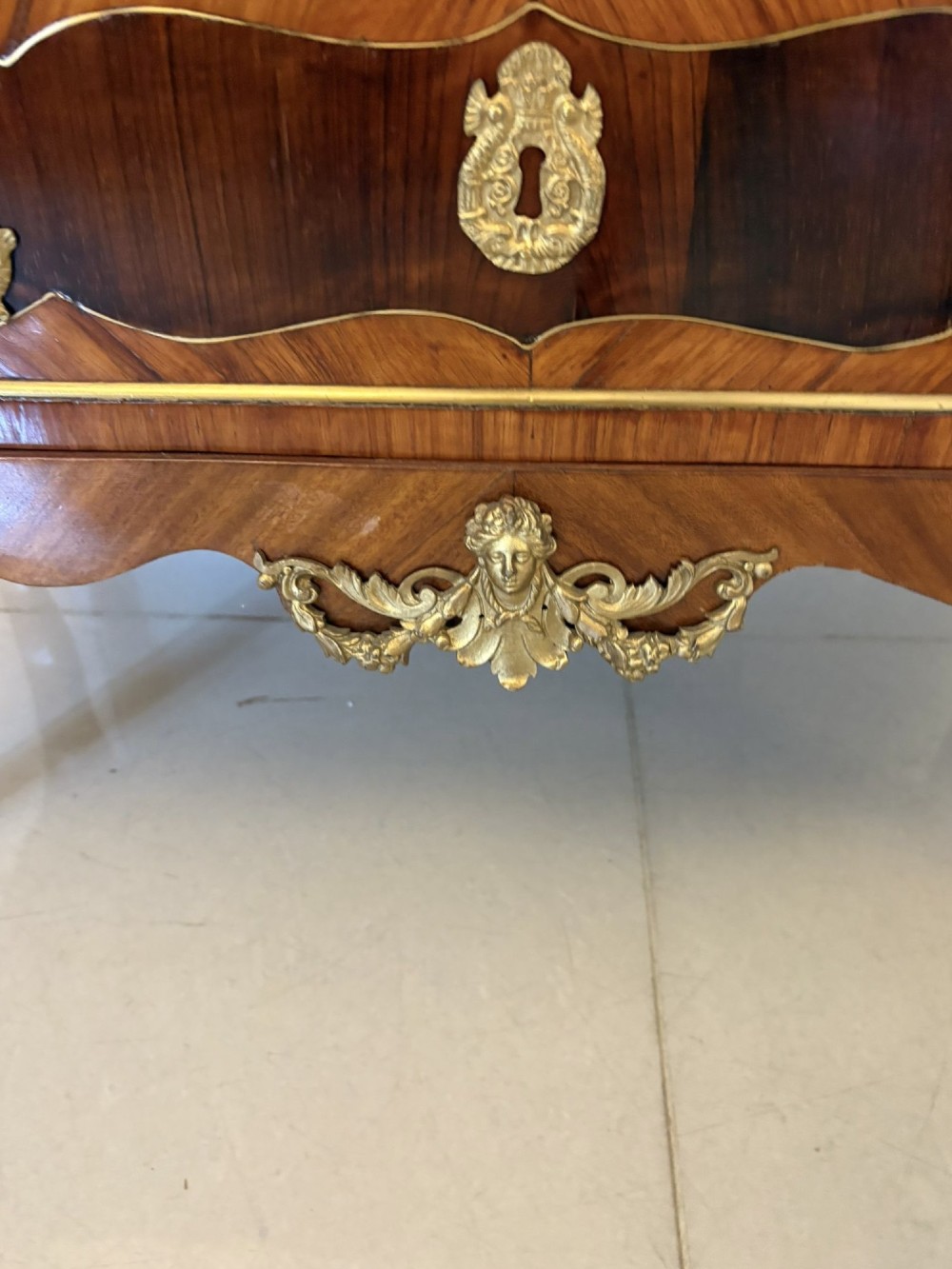An antique French style commode chest featuring a dark grey veined marble top, decorative walnut veneers, cast brass mounts, and cabriole legs. View IV