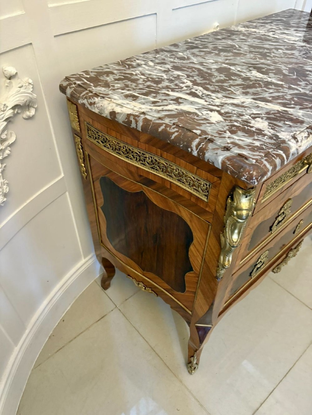 An antique French style commode chest featuring a dark grey veined marble top, decorative walnut veneers, cast brass mounts, and cabriole legs. View IX