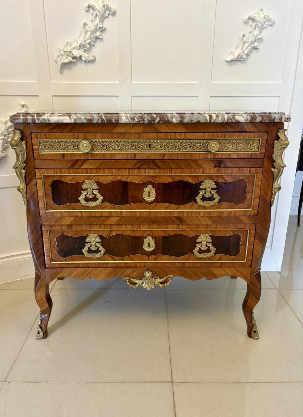 An antique French style commode chest featuring a dark grey veined marble top, decorative walnut veneers, cast brass mounts, and cabriole legs. View XII