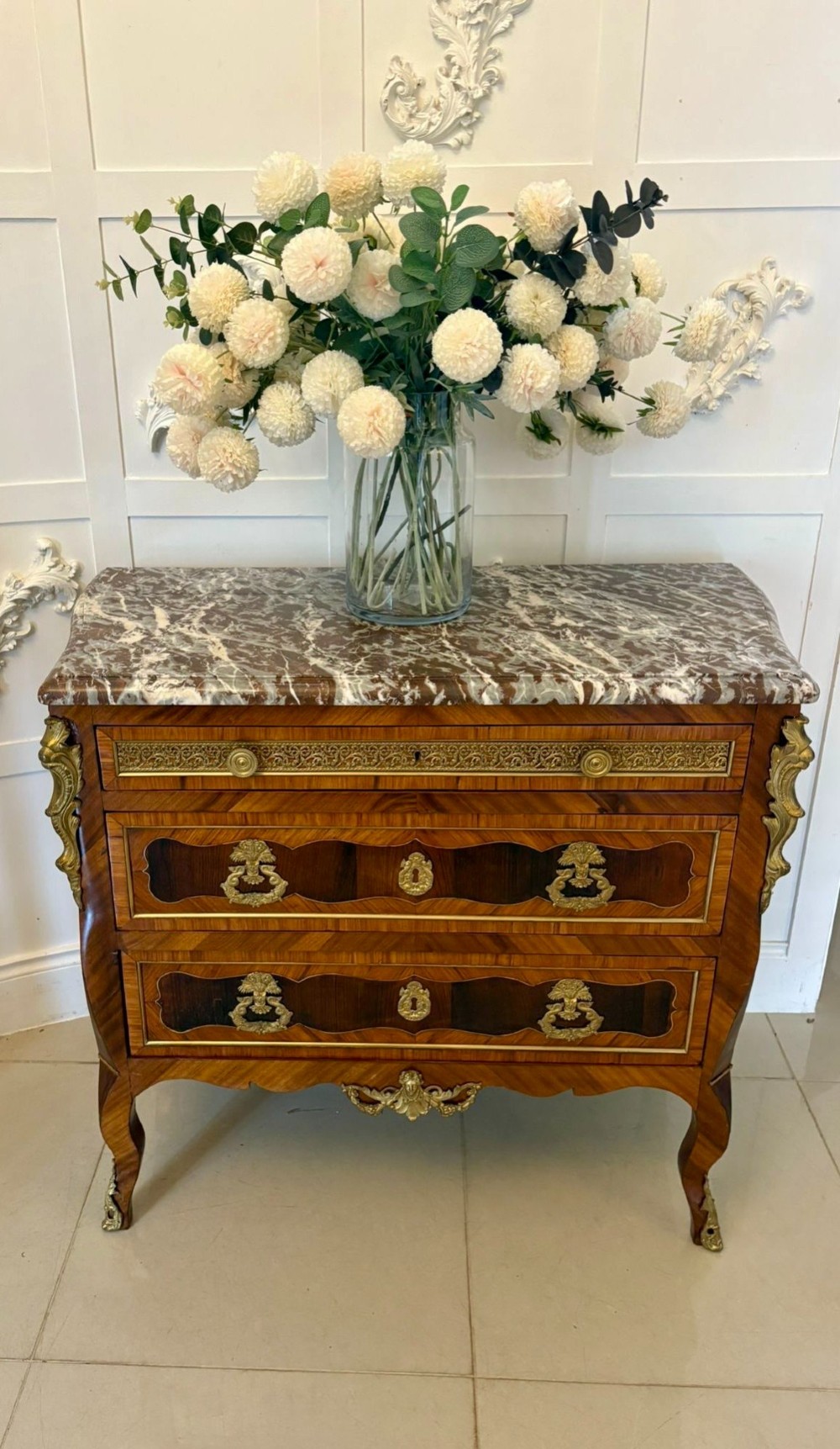An antique French style commode chest featuring a dark grey veined marble top, decorative walnut veneers, cast brass mounts, and cabriole legs. View XIV
