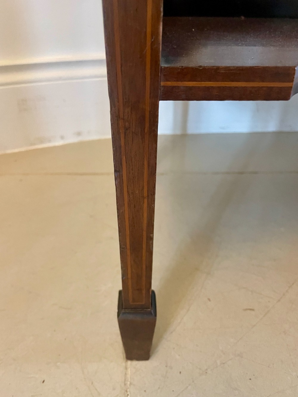 An Edwardian mahogany display cabinet featuring glazed doors with astragal bars, a central marquetry inlay medallion, tapering square legs, and an undertier shelf. View IV