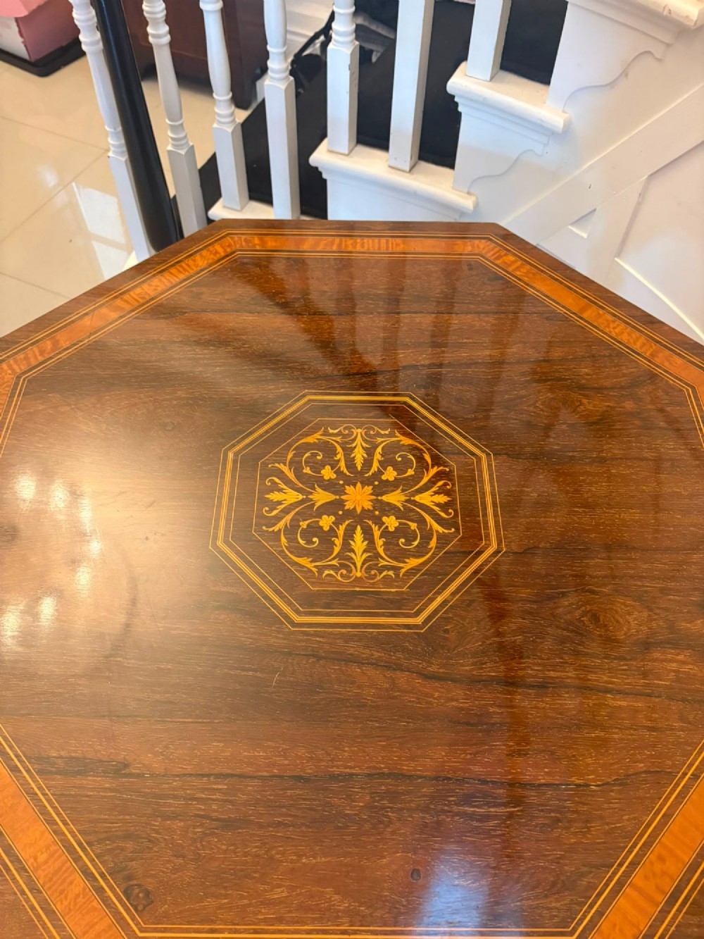 An octagonal Victorian rosewood centre table with intricate central marquetry inlay, crossbanded borders, and spiral turned legs joined by a lower stretcher. View III
