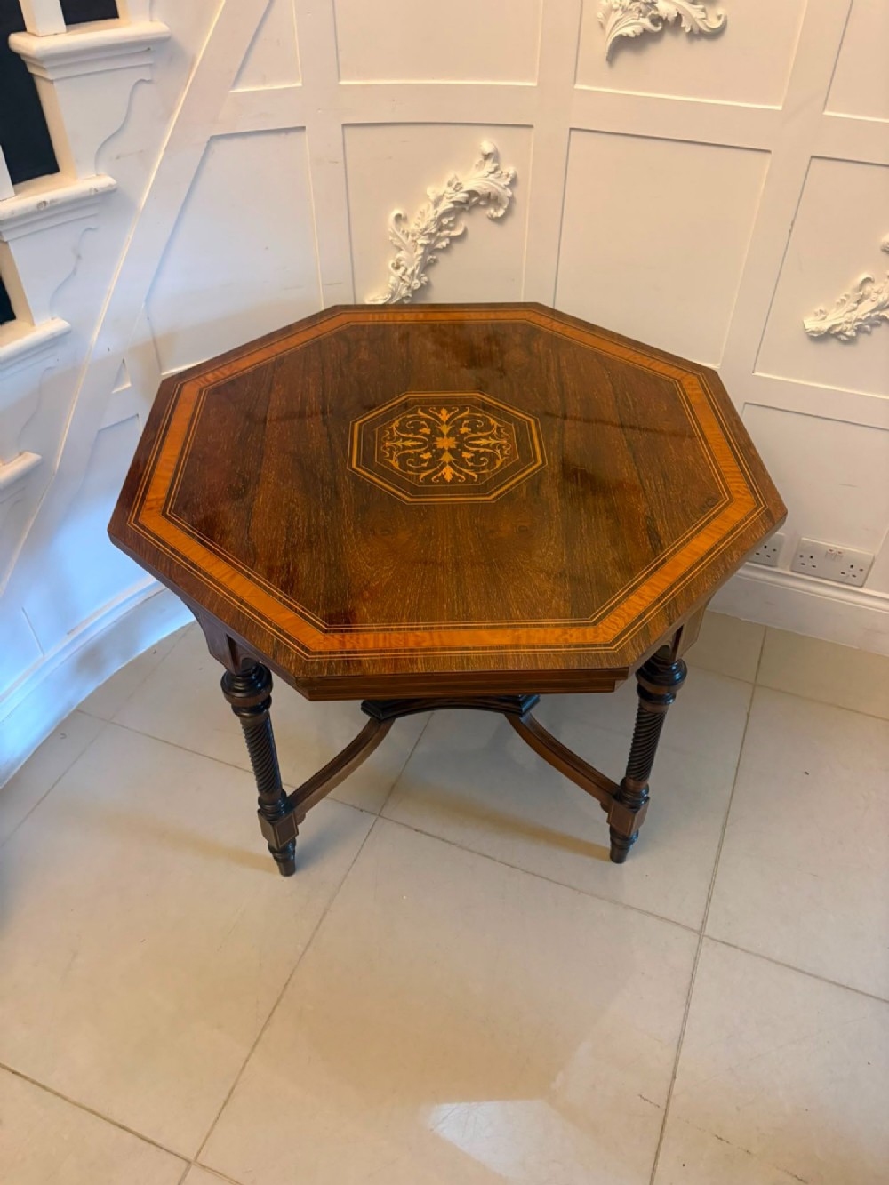 An octagonal Victorian rosewood centre table with intricate central marquetry inlay, crossbanded borders, and spiral turned legs joined by a lower stretcher. View IX