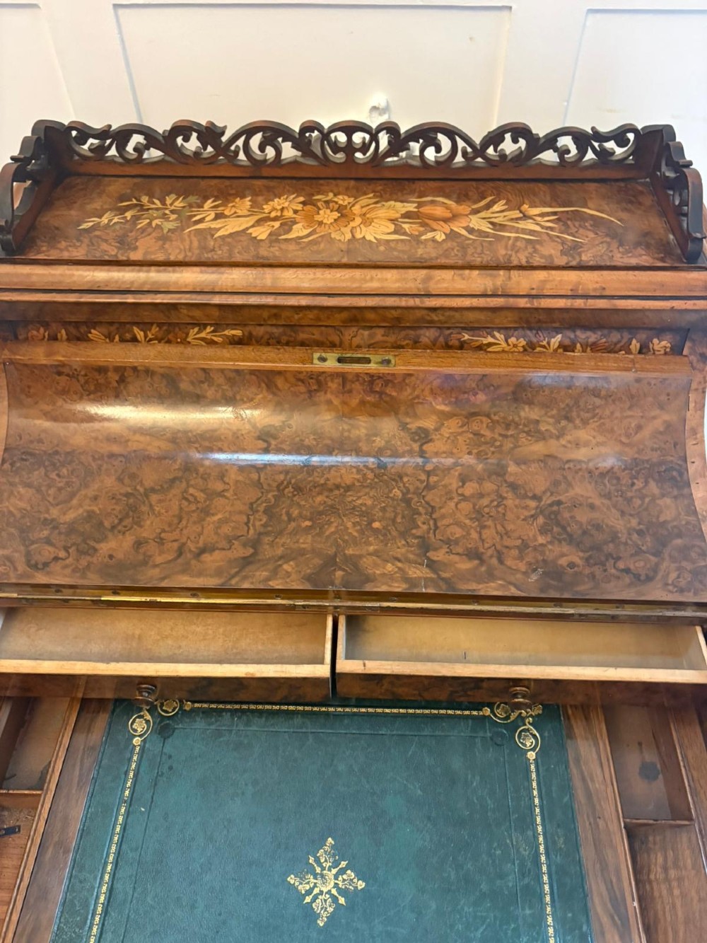 A Victorian burr walnut piano top davenport desk featuring floral marquetry, side drawers with turned wooden knobs, and carved supports. View V