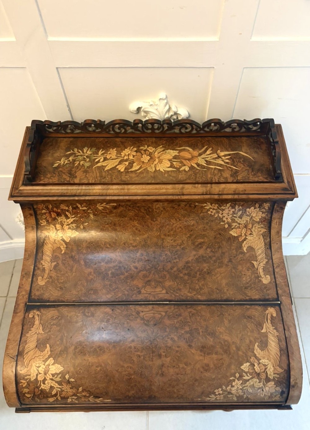 A Victorian burr walnut piano top davenport desk featuring floral marquetry, side drawers with turned wooden knobs, and carved supports. View VIII