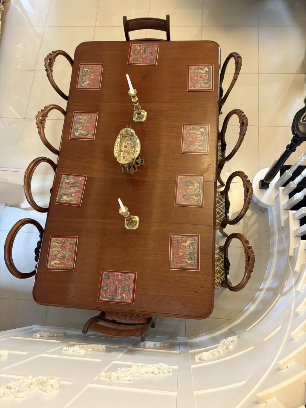A large Victorian extending mahogany dining table featuring rounded corners, turned legs, brass castors, and a polished dark wood surface. View IV