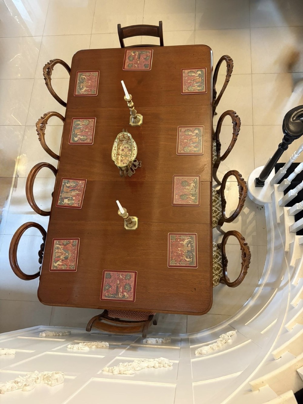 A large Victorian extending mahogany dining table featuring rounded corners, turned legs, brass castors, and a polished dark wood surface. View V