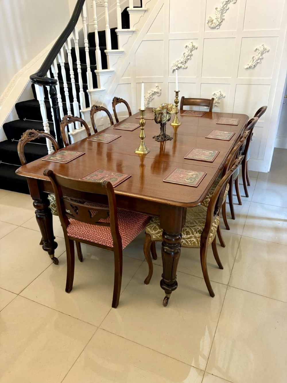 A large Victorian extending mahogany dining table featuring rounded corners, turned legs, brass castors, and a polished dark wood surface. View VII
