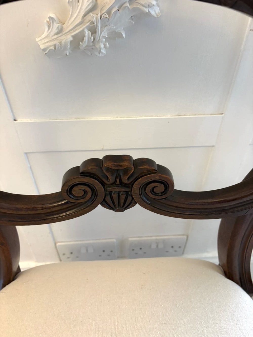 A set of ten antique English Regency mahogany dining chairs with carved balloon backs, cream upholstered seats, and turned front legs. View VI