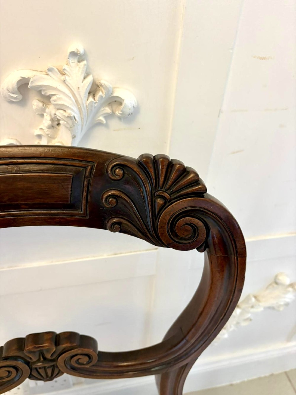 A set of ten antique English Regency mahogany dining chairs with carved balloon backs, cream upholstered seats, and turned front legs. View VII