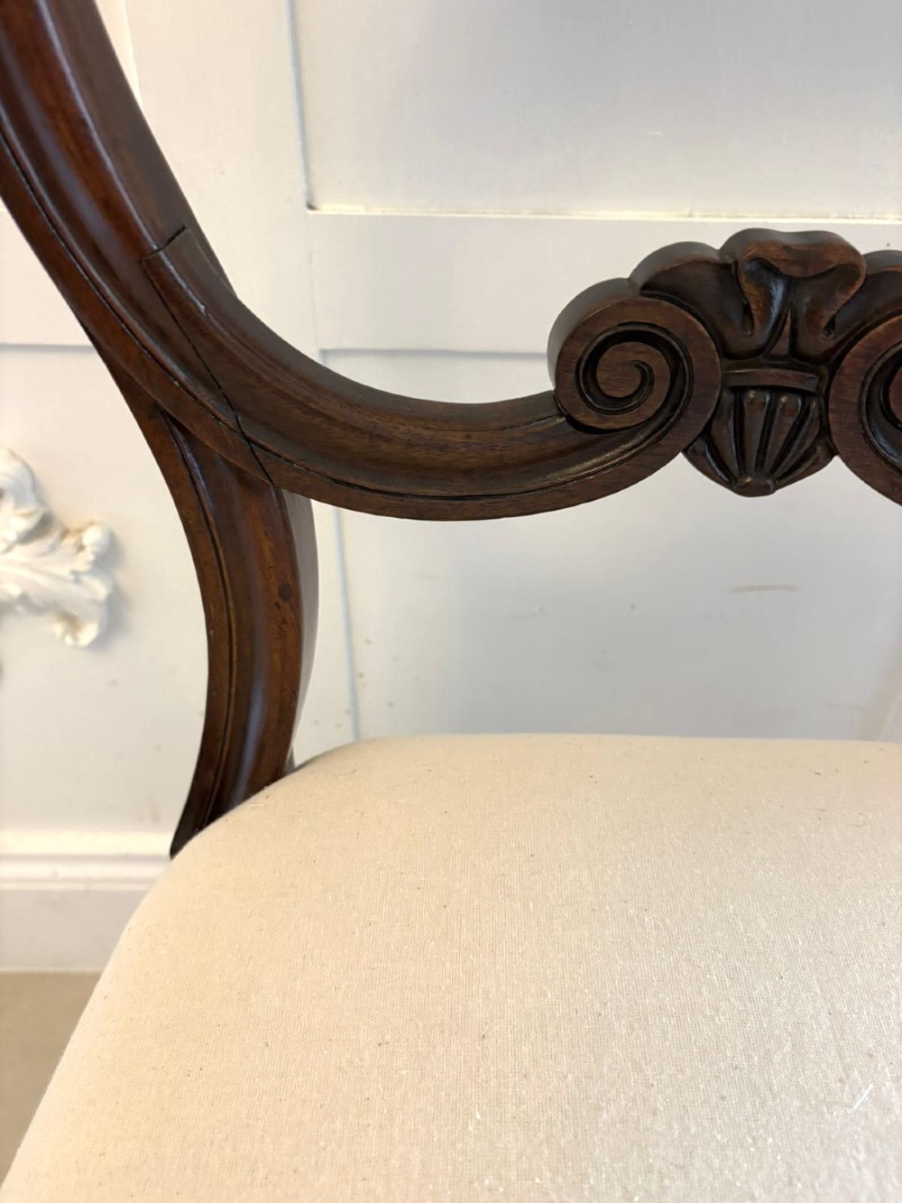 A set of ten antique English Regency mahogany dining chairs with carved balloon backs, cream upholstered seats, and turned front legs. View XIII