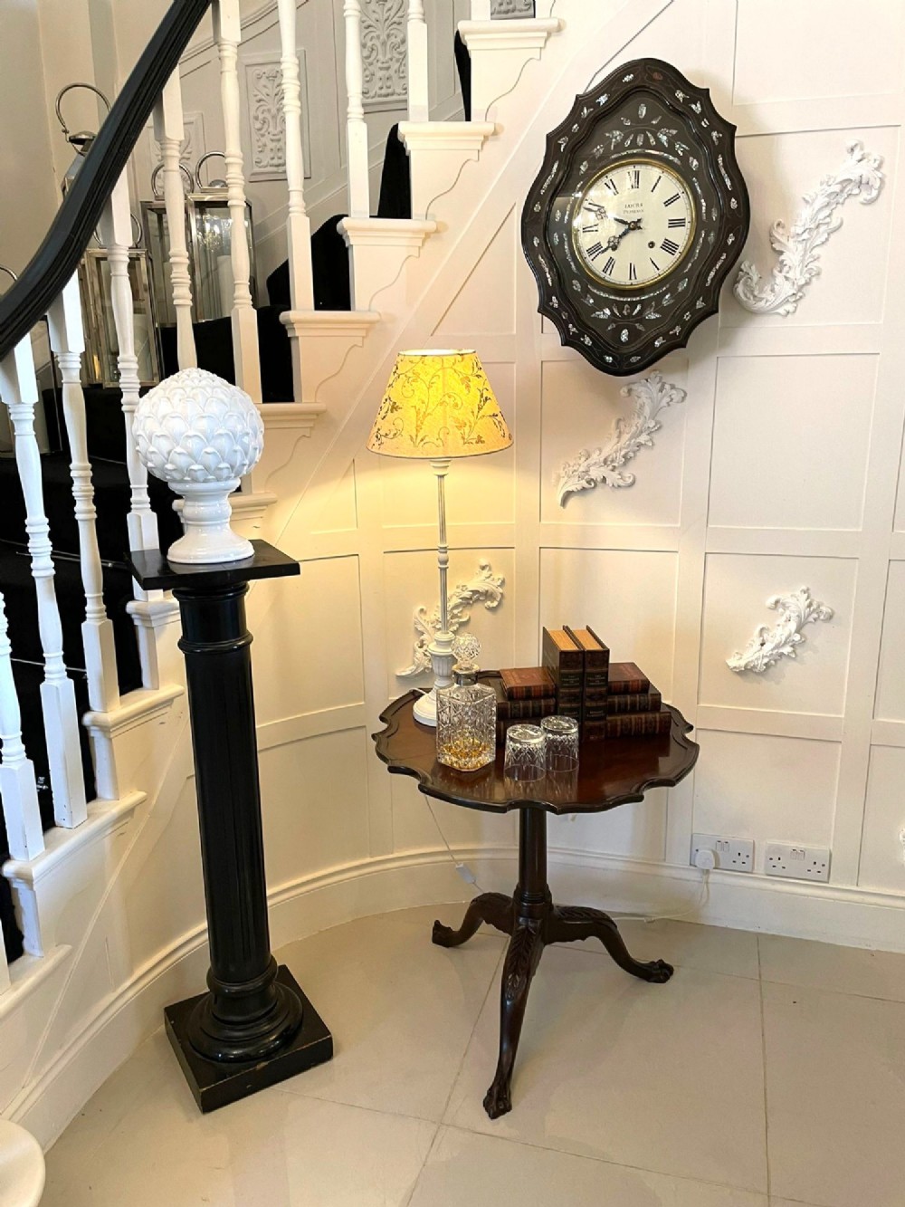An antique George III mahogany tilt-top table featuring a scalloped pie-crust rim supported by a carved central pedestal and tripod cabriole legs. View III