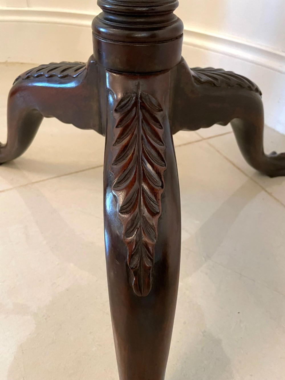 An antique George III mahogany tilt-top table featuring a scalloped pie-crust rim supported by a carved central pedestal and tripod cabriole legs. View IX