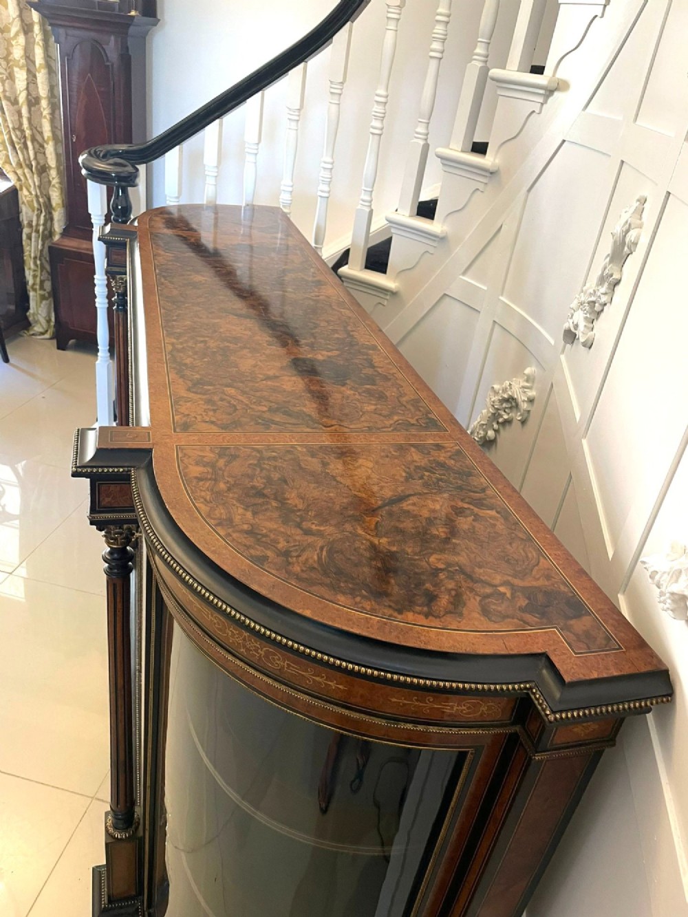 A Victorian burr walnut credenza featuring inlaid amboyna borders, central mirrored doors, curved side glass cabinets, and brass ormolu mounts. View VIII