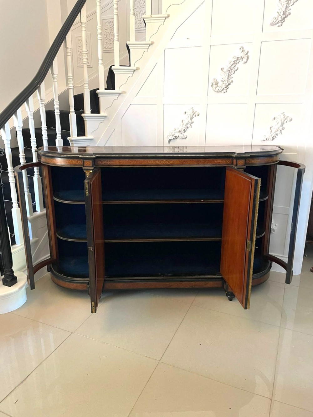 A Victorian burr walnut credenza featuring inlaid amboyna borders, central mirrored doors, curved side glass cabinets, and brass ormolu mounts. View IX