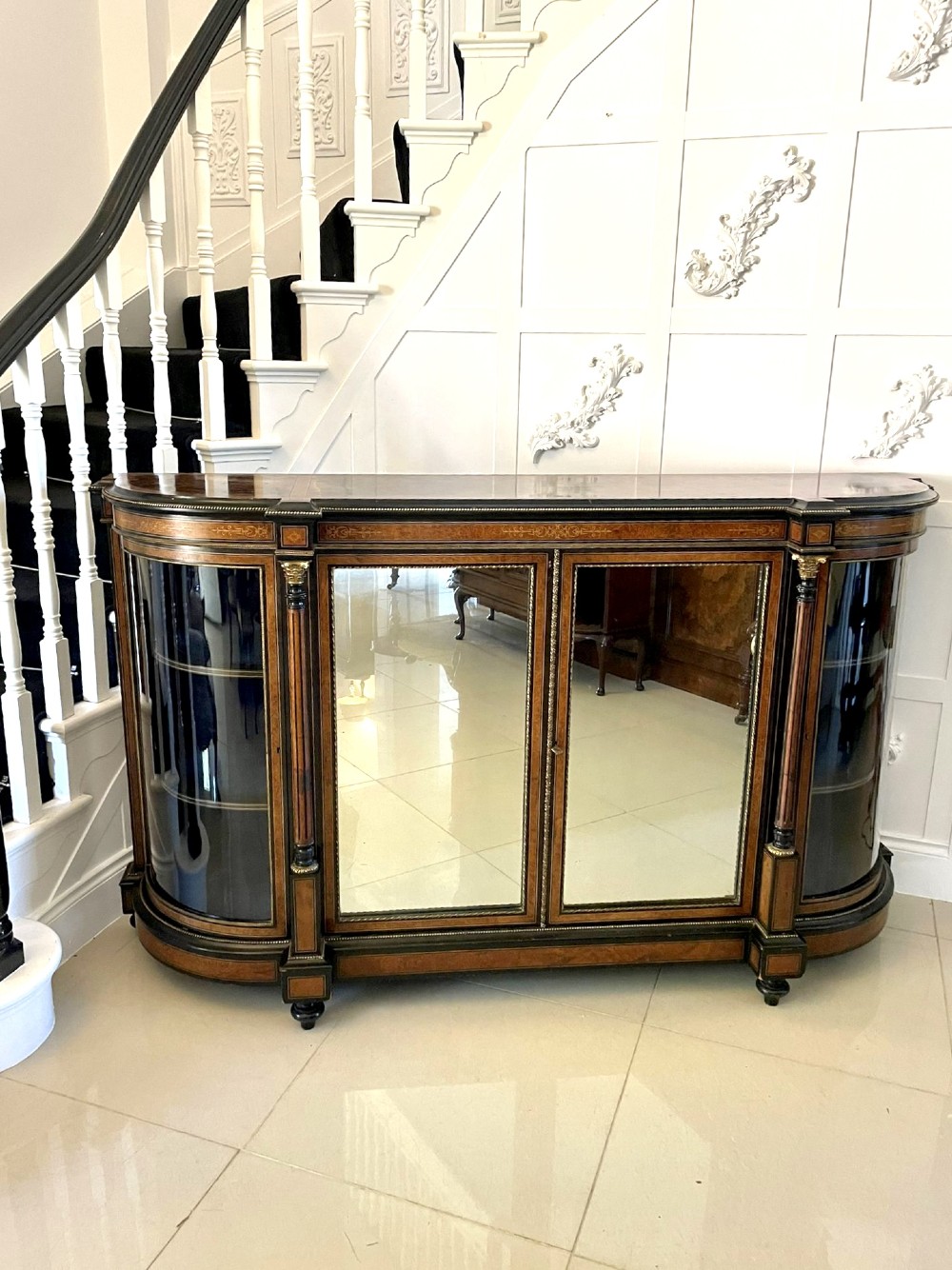 A Victorian burr walnut credenza featuring inlaid amboyna borders, central mirrored doors, curved side glass cabinets, and brass ormolu mounts. View X