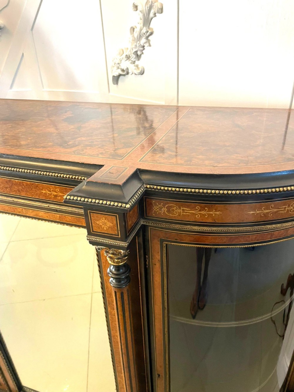 A Victorian burr walnut credenza featuring inlaid amboyna borders, central mirrored doors, curved side glass cabinets, and brass ormolu mounts. View XI