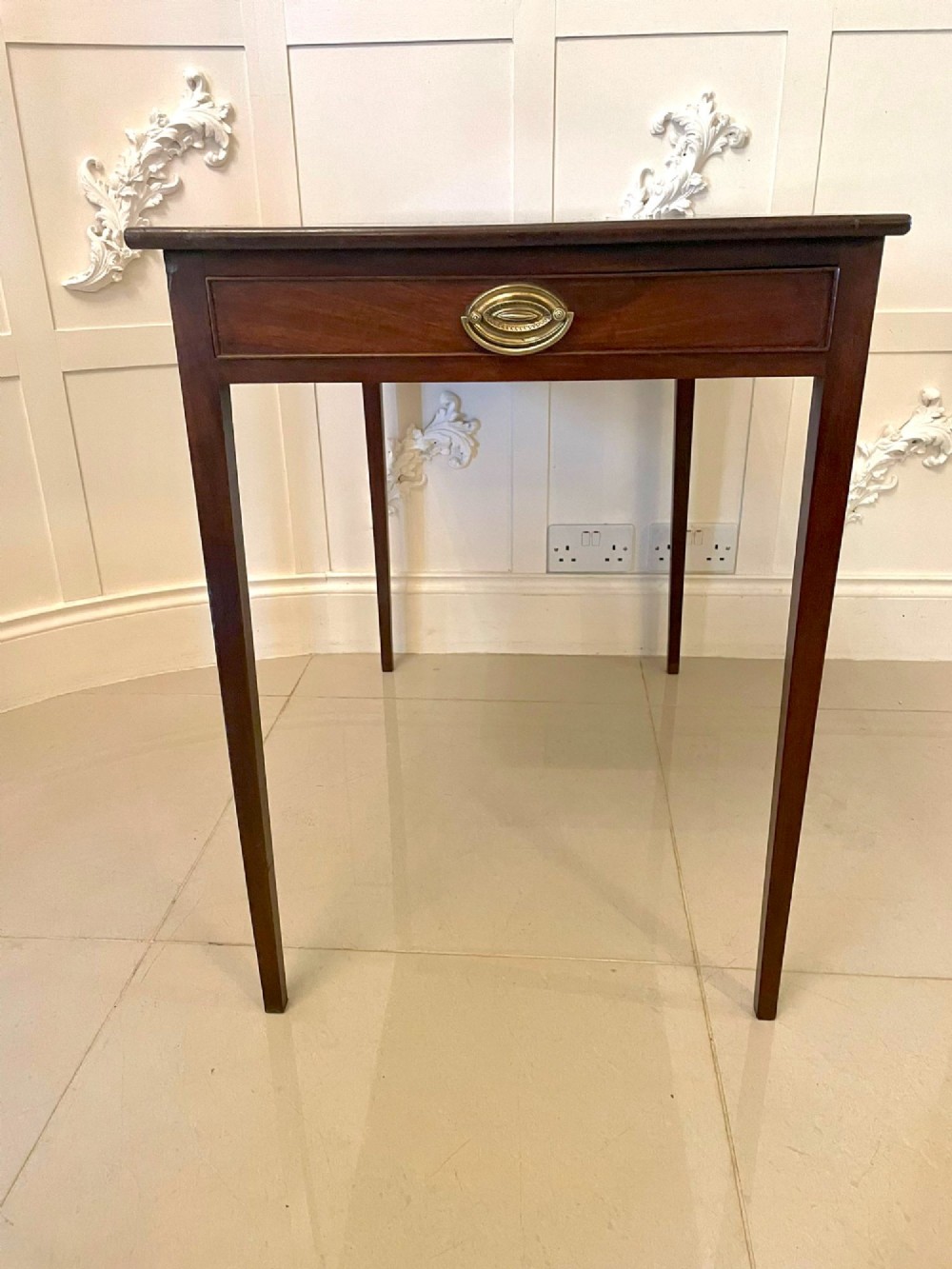 An antique George III mahogany side table featuring square tapered legs and a single side drawer with a brass handle. View II