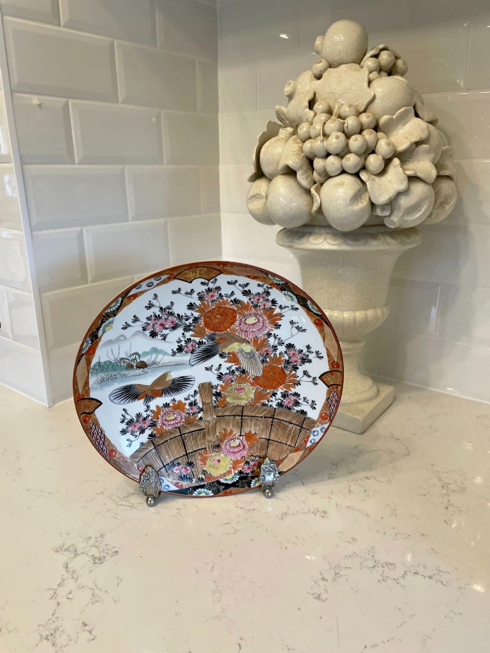A shallow circular Japanese Kutani porcelain bowl featuring hand-painted floral chrysanthemum patterns, birds in flight, and detailed decorative borders in terracotta, red, black, and gold. View IV