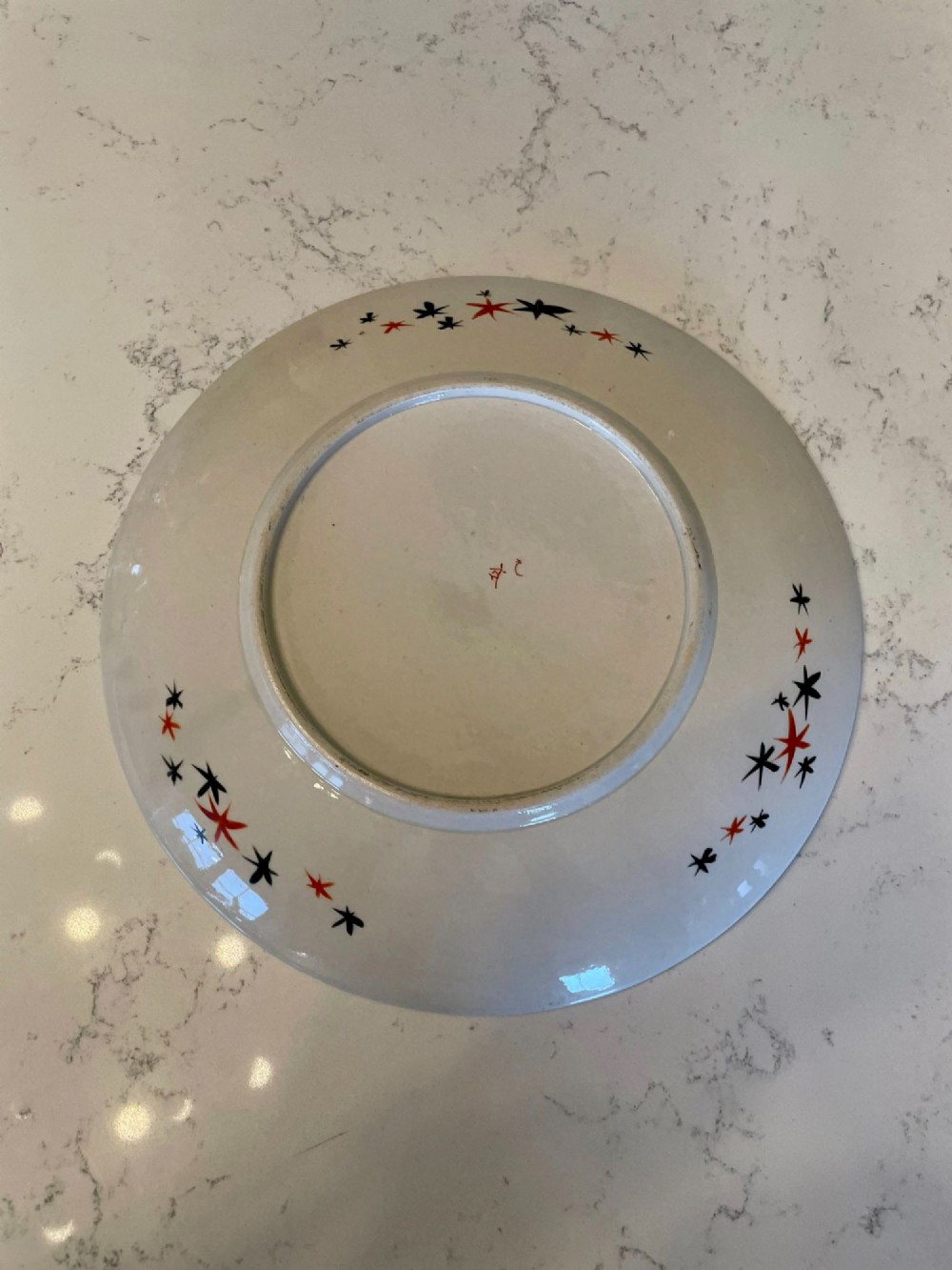 A shallow circular Japanese Kutani porcelain bowl featuring hand-painted floral chrysanthemum patterns, birds in flight, and detailed decorative borders in terracotta, red, black, and gold. View V