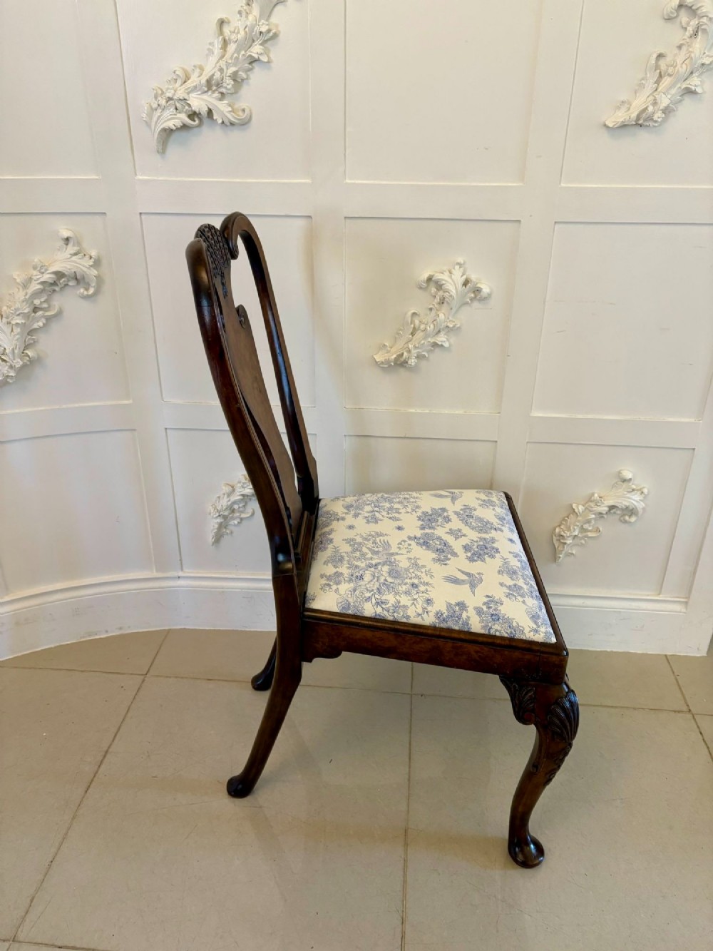 A set of six Victorian burr walnut dining chairs featuring carved top rails, vase-shaped splats, patterned upholstery, and cabriole legs. View IV
