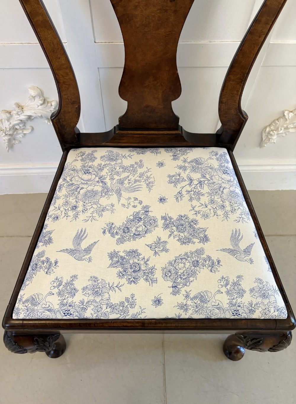 A set of six Victorian burr walnut dining chairs featuring carved top rails, vase-shaped splats, patterned upholstery, and cabriole legs. View V