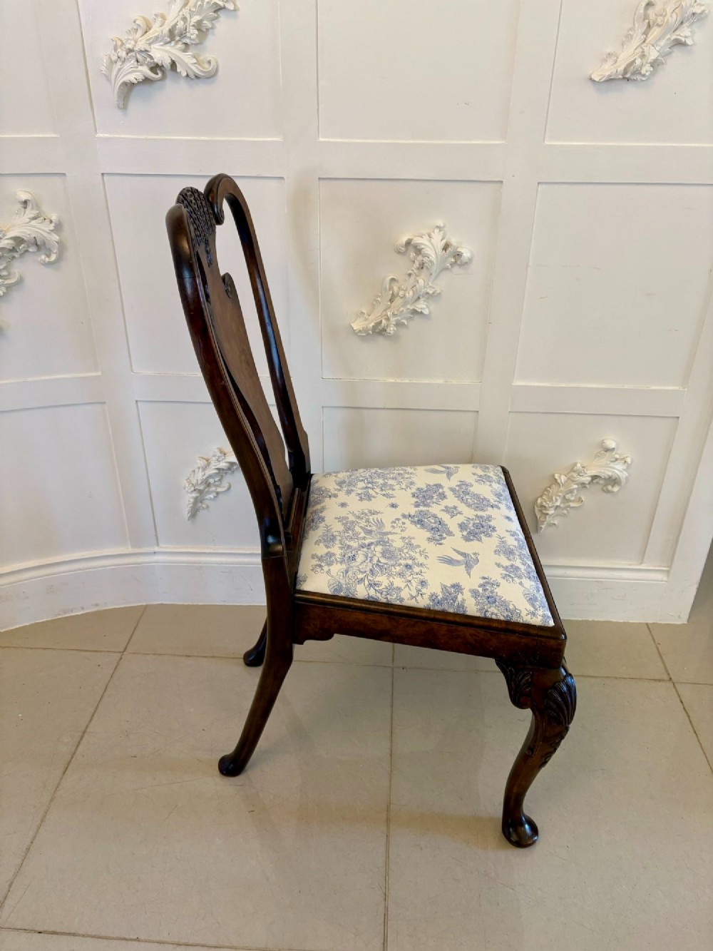 A set of six Victorian burr walnut dining chairs featuring carved top rails, vase-shaped splats, patterned upholstery, and cabriole legs. View VI