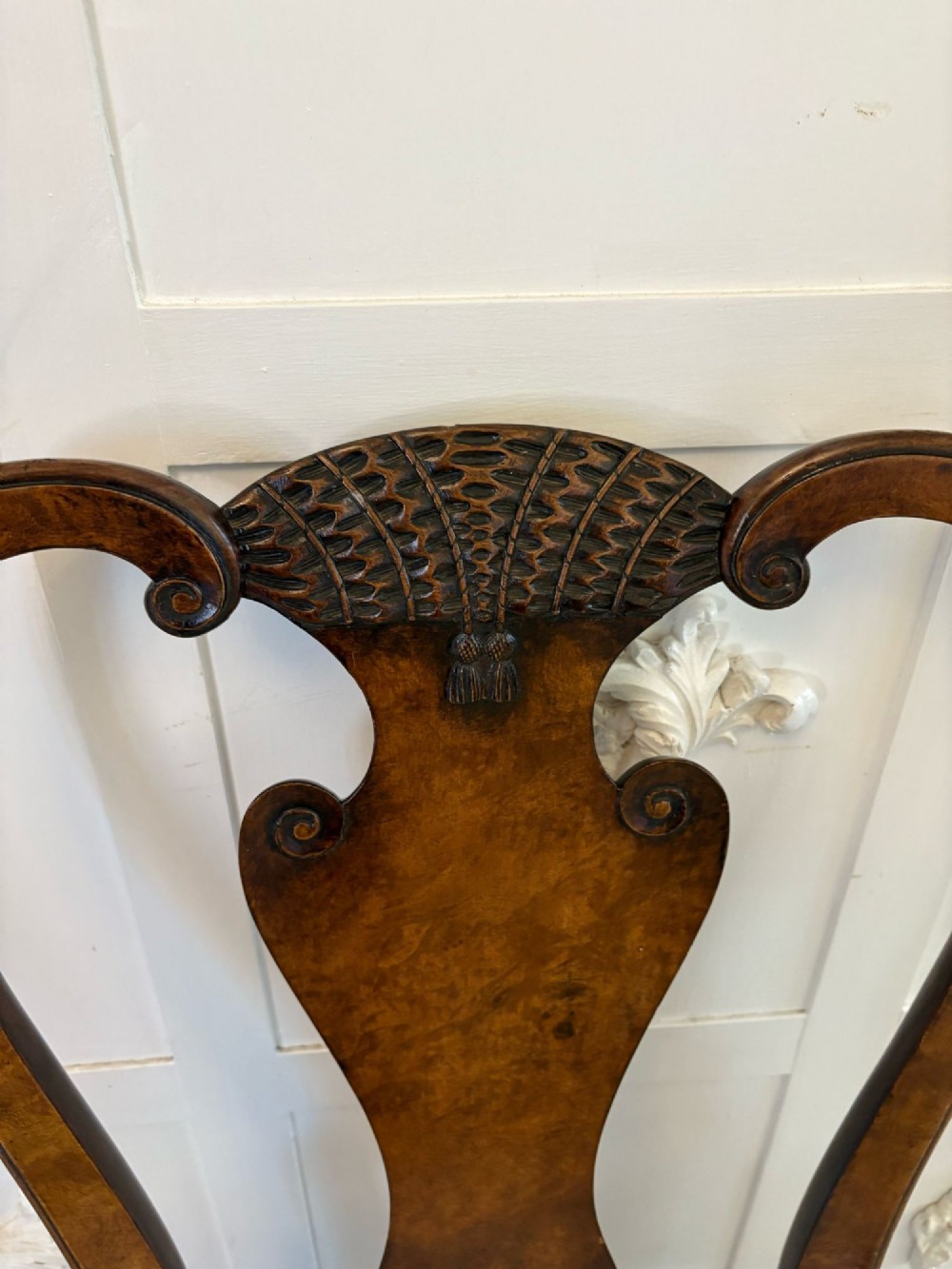 A set of six Victorian burr walnut dining chairs featuring carved top rails, vase-shaped splats, patterned upholstery, and cabriole legs. View X