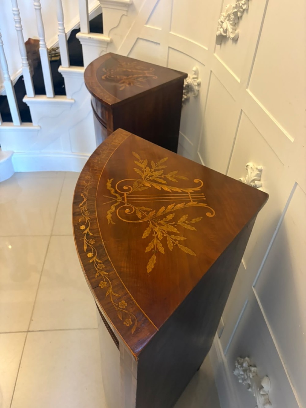 A pair of Victorian mahogany corner cabinets featuring curved bow fronts with floral urn marquetry inlays and tapered square feet. View VII