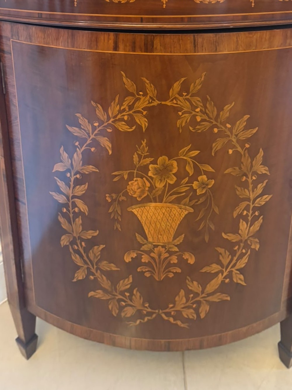 A pair of Victorian mahogany corner cabinets featuring curved bow fronts with floral urn marquetry inlays and tapered square feet. View X