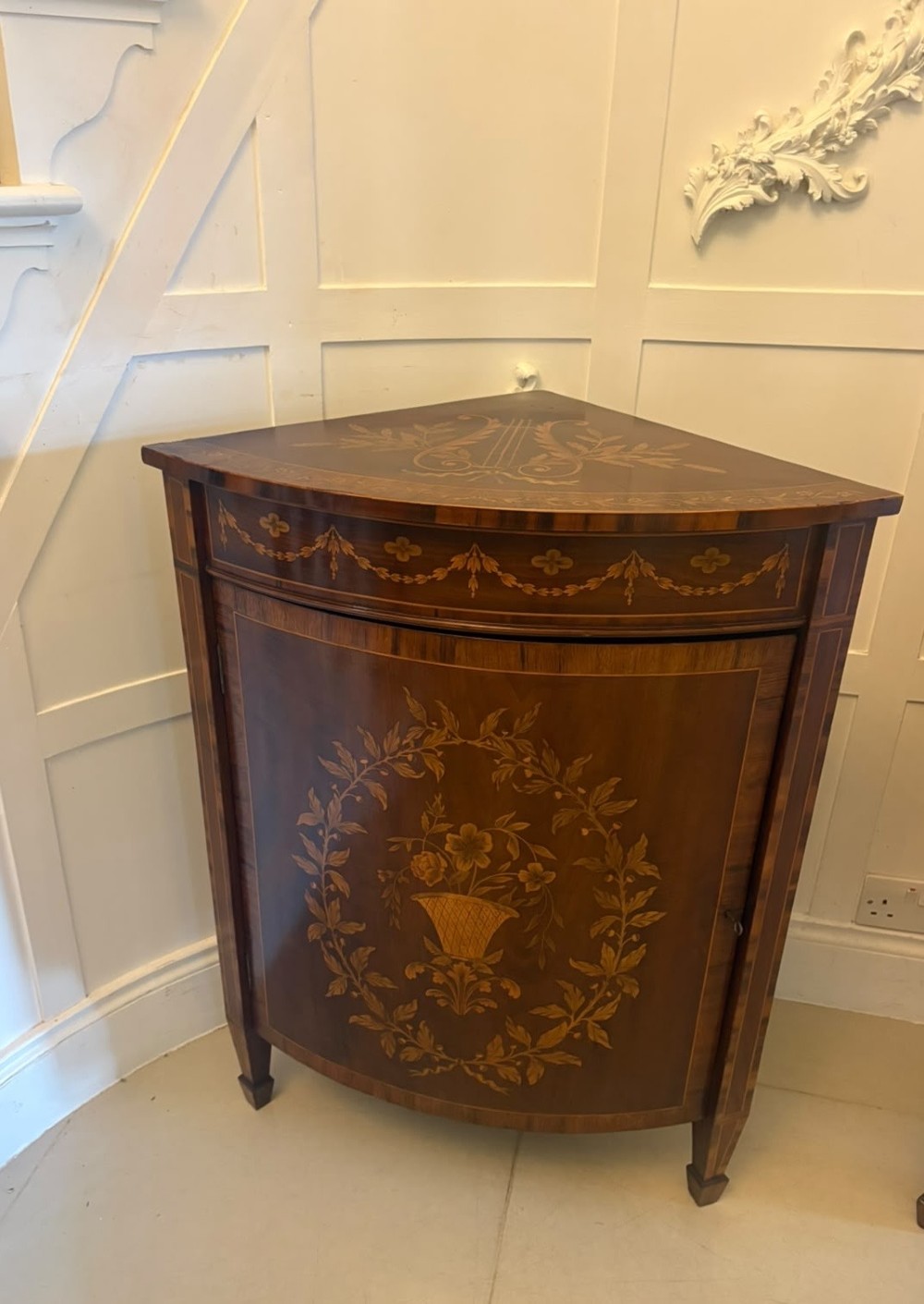 A pair of Victorian mahogany corner cabinets featuring curved bow fronts with floral urn marquetry inlays and tapered square feet. View XII