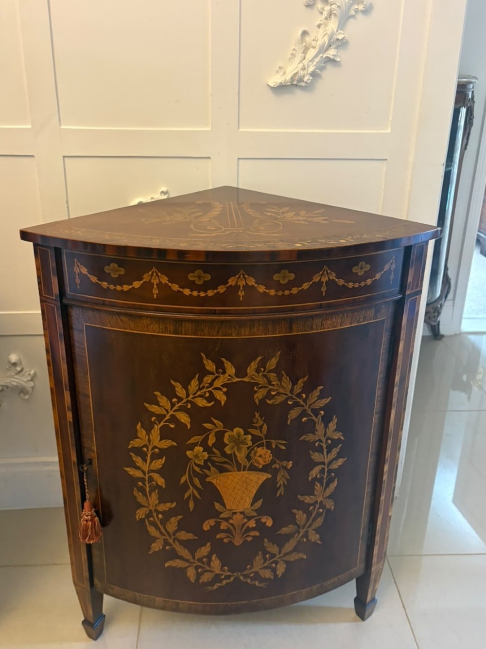 A pair of Victorian mahogany corner cabinets featuring curved bow fronts with floral urn marquetry inlays and tapered square feet. View XIII