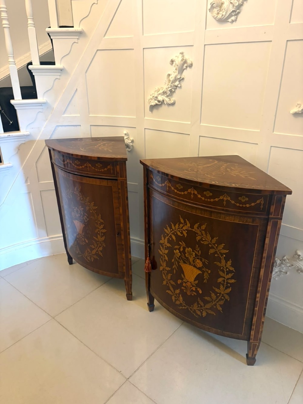 A pair of Victorian mahogany corner cabinets featuring curved bow fronts with floral urn marquetry inlays and tapered square feet. View XIV