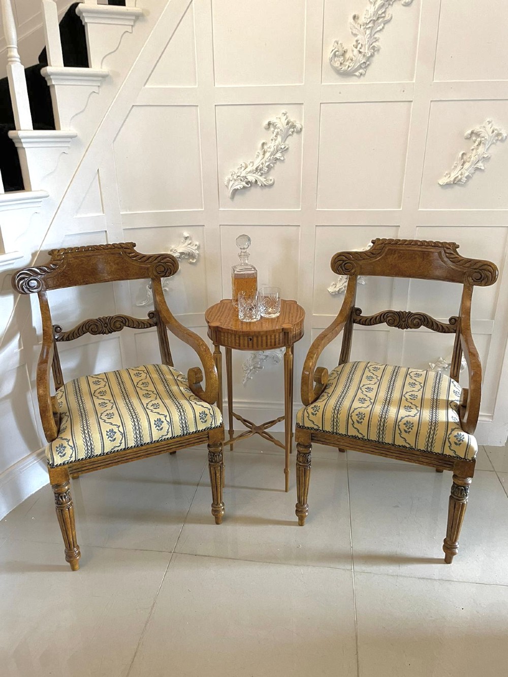 A set of eight antique Regency style dining chairs with faux birds eye maple painted decoration, carved cresting rails, turned legs, and striped upholstery. View III