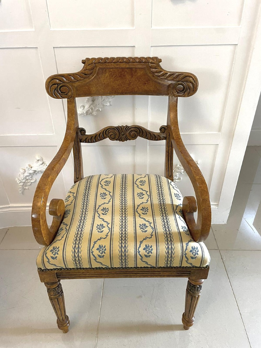 A set of eight antique Regency style dining chairs with faux birds eye maple painted decoration, carved cresting rails, turned legs, and striped upholstery. View V
