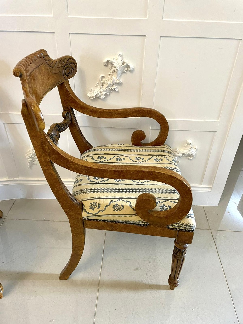 A set of eight antique Regency style dining chairs with faux birds eye maple painted decoration, carved cresting rails, turned legs, and striped upholstery. View VII