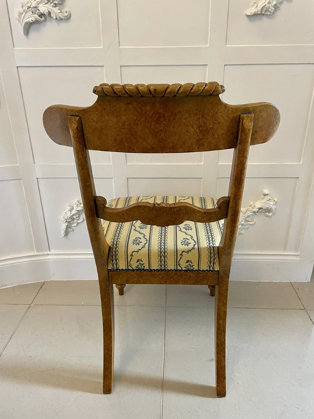 A set of eight antique Regency style dining chairs with faux birds eye maple painted decoration, carved cresting rails, turned legs, and striped upholstery. View XII
