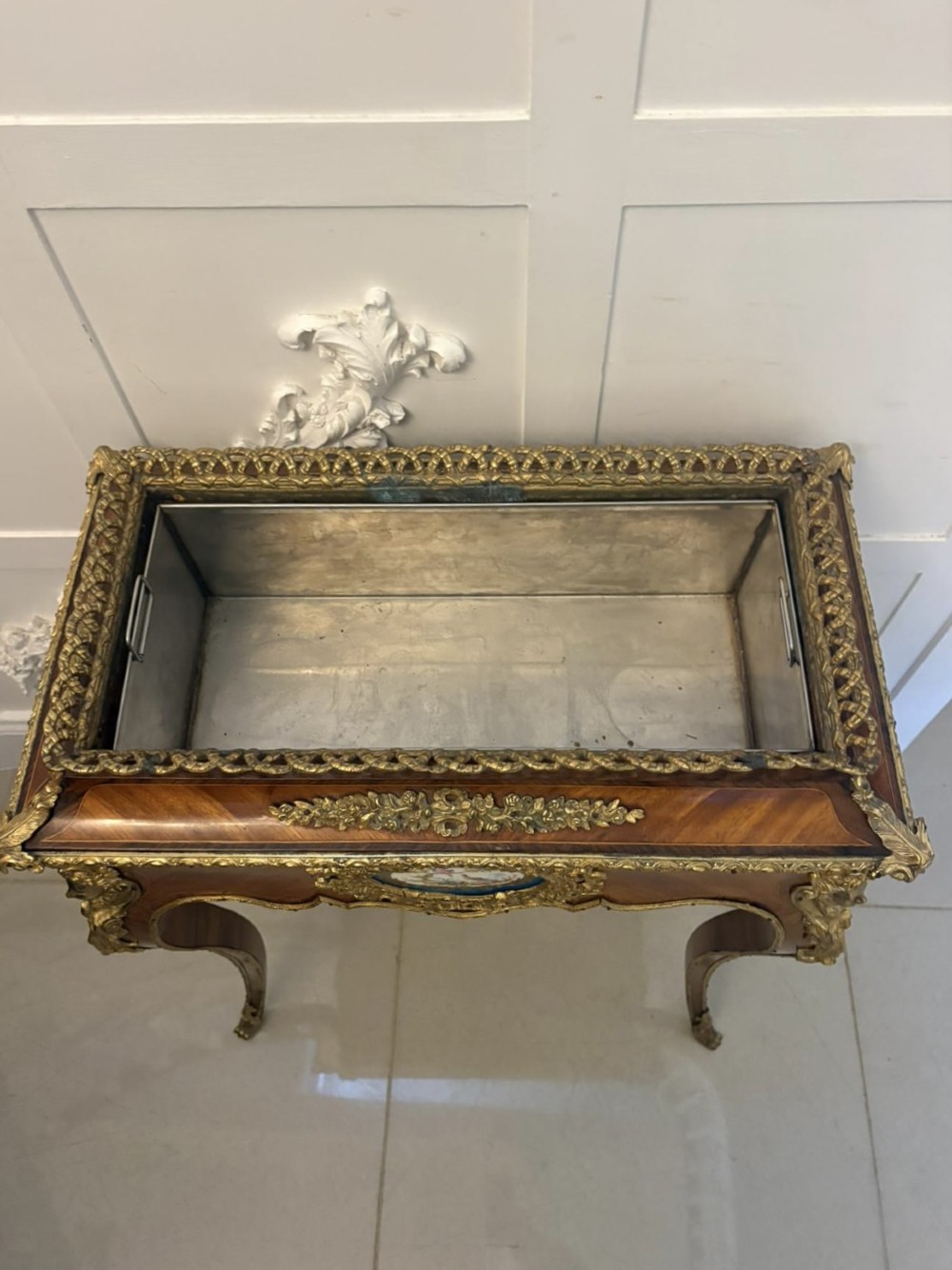 A Louis XV style kingwood jardiniere stand with ornate gilt-bronze ormolu mounts, cabriole legs, and a central porcelain plaque. View IV