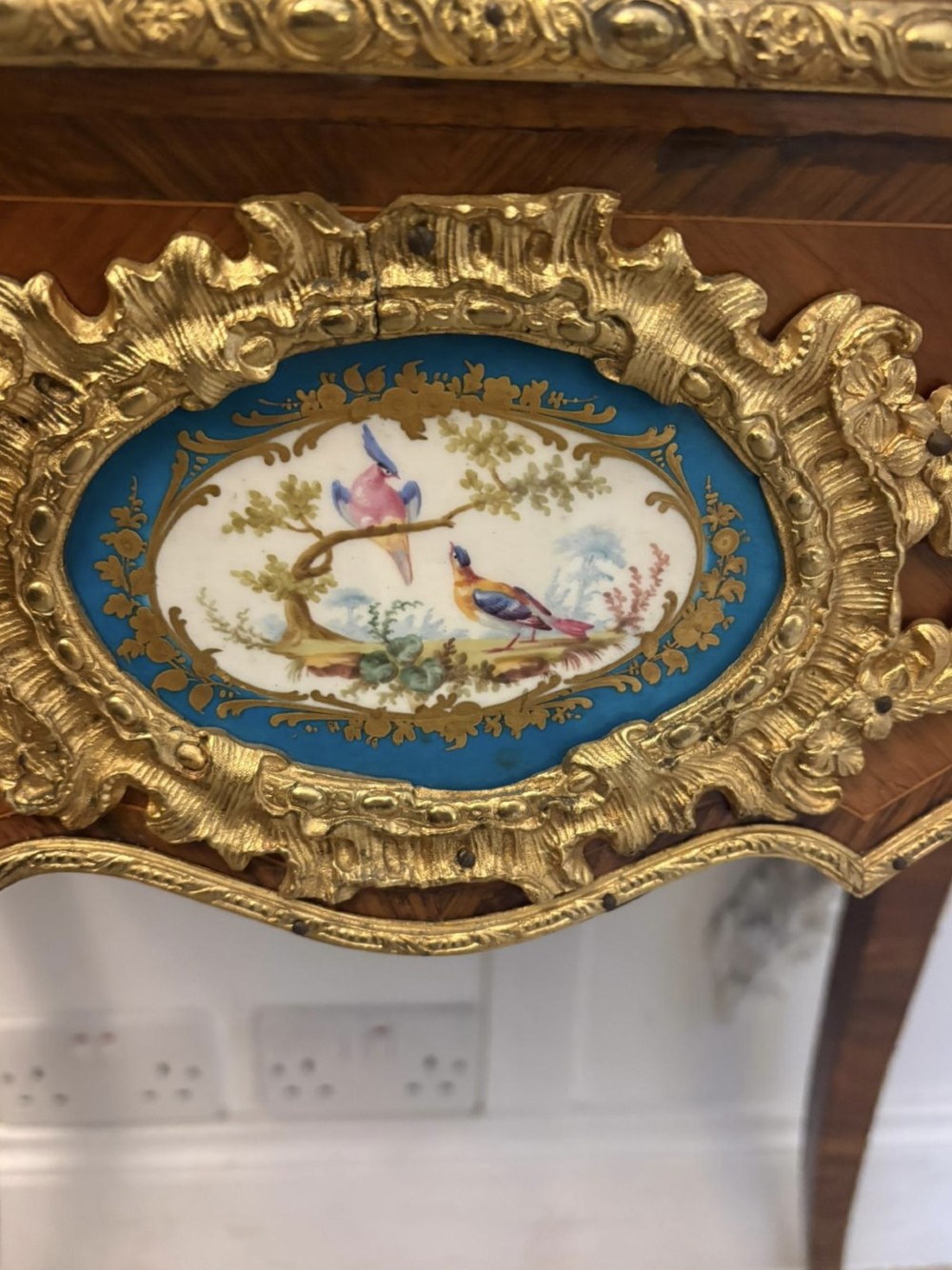 A Louis XV style kingwood jardiniere stand with ornate gilt-bronze ormolu mounts, cabriole legs, and a central porcelain plaque. View V