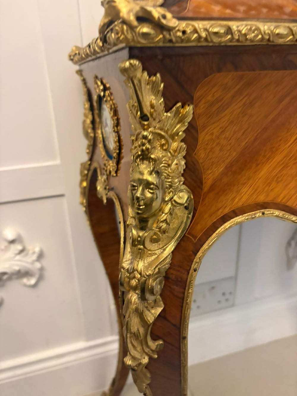 A Louis XV style kingwood jardiniere stand with ornate gilt-bronze ormolu mounts, cabriole legs, and a central porcelain plaque. View VI