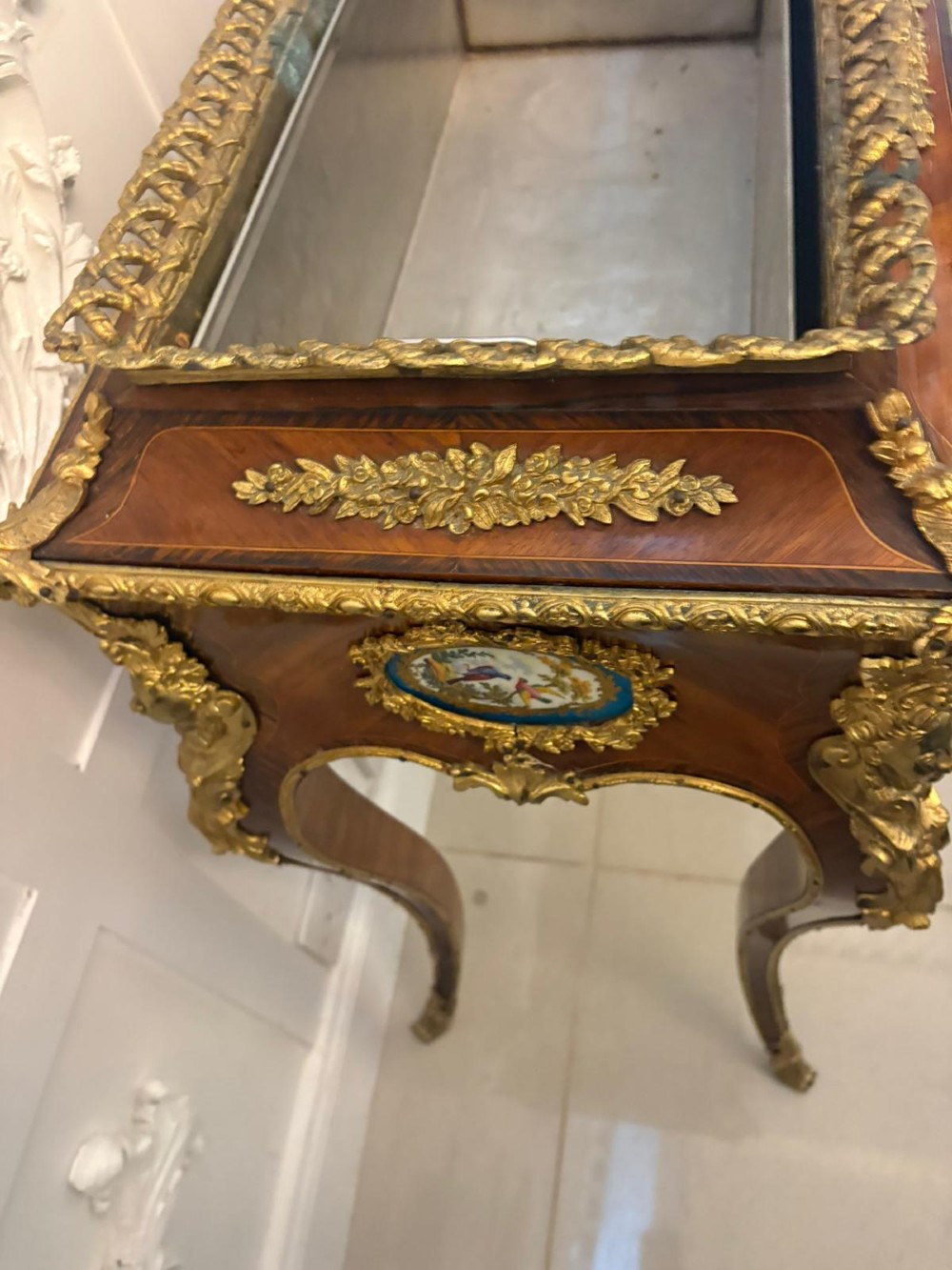 A Louis XV style kingwood jardiniere stand with ornate gilt-bronze ormolu mounts, cabriole legs, and a central porcelain plaque. View VIII