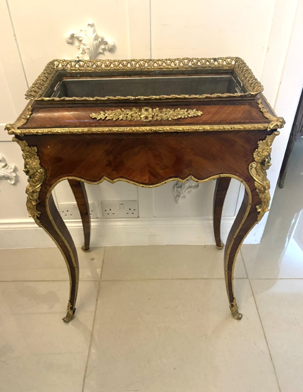 A Louis XV style kingwood jardiniere stand with ornate gilt-bronze ormolu mounts, cabriole legs, and a central porcelain plaque. View XII