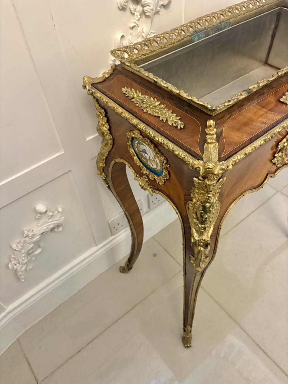 A Louis XV style kingwood jardiniere stand with ornate gilt-bronze ormolu mounts, cabriole legs, and a central porcelain plaque. View XIII