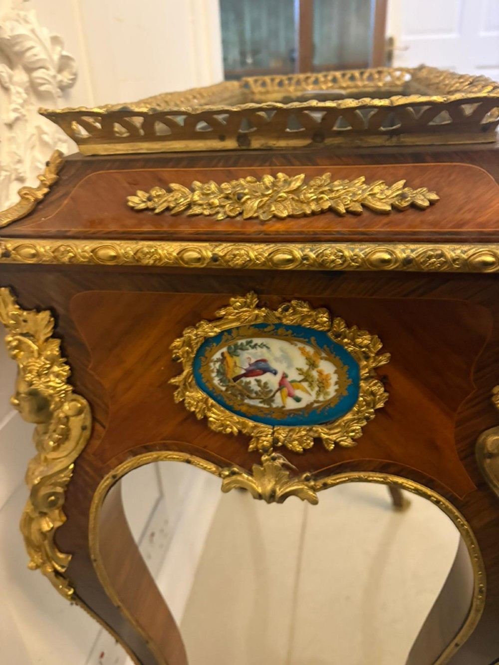 A Louis XV style kingwood jardiniere stand with ornate gilt-bronze ormolu mounts, cabriole legs, and a central porcelain plaque. View XIV