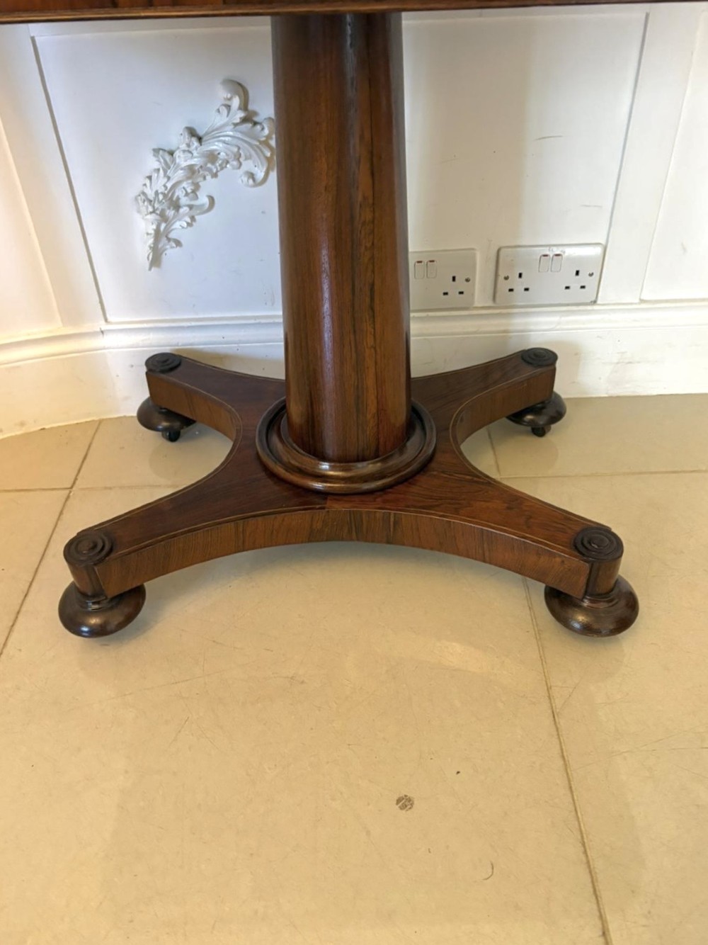 A Regency rosewood card table featuring fine brass inlay stringing, a fold-over swivel top, a central pedestal stem, and a quadform base on round feet. View VII