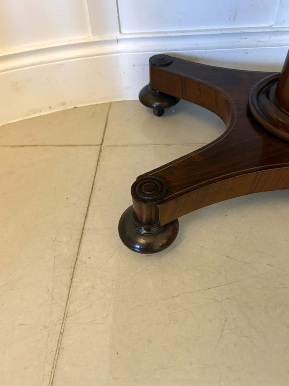 A Regency rosewood card table featuring fine brass inlay stringing, a fold-over swivel top, a central pedestal stem, and a quadform base on round feet. View VIII