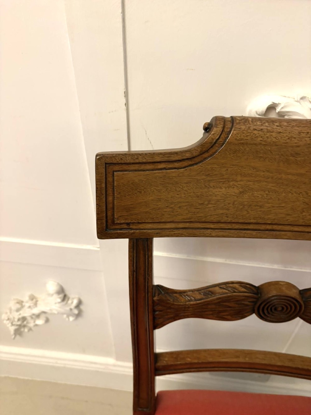 A set of twelve Regency mahogany dining chairs with carved mid-rails and coral fabric upholstered seats, including two matching carver armchairs. View X