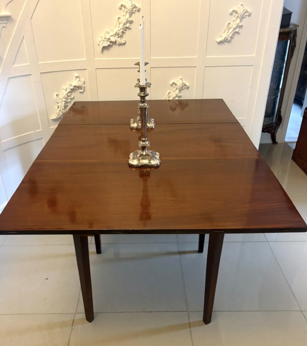 An antique Georgian mahogany drop-leaf dining table shown folded closed with square straight legs and a polished dark wood surface. View VIII