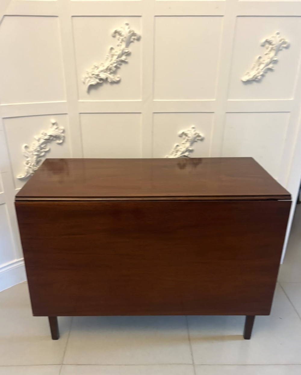 An antique Georgian mahogany drop-leaf dining table shown folded closed with square straight legs and a polished dark wood surface. View XV