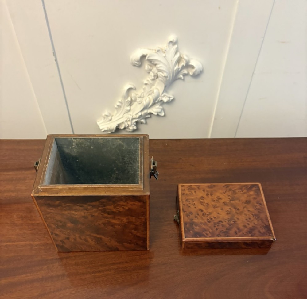 An upright Victorian travelling tea caddy crafted from amboyna burl wood with line inlay and a brass front latch. View VIII
